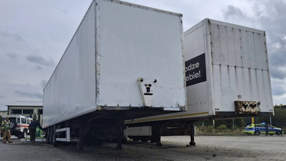 Дві білі напівпричепи на стоянці поруч із поліцією та рятувальниками