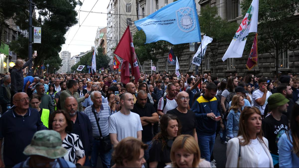 Натовп людей з університетськими прапорами крокує вулицею Белграда